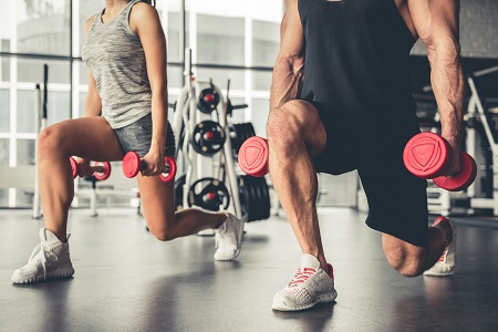 Two people working out with weights in each hand